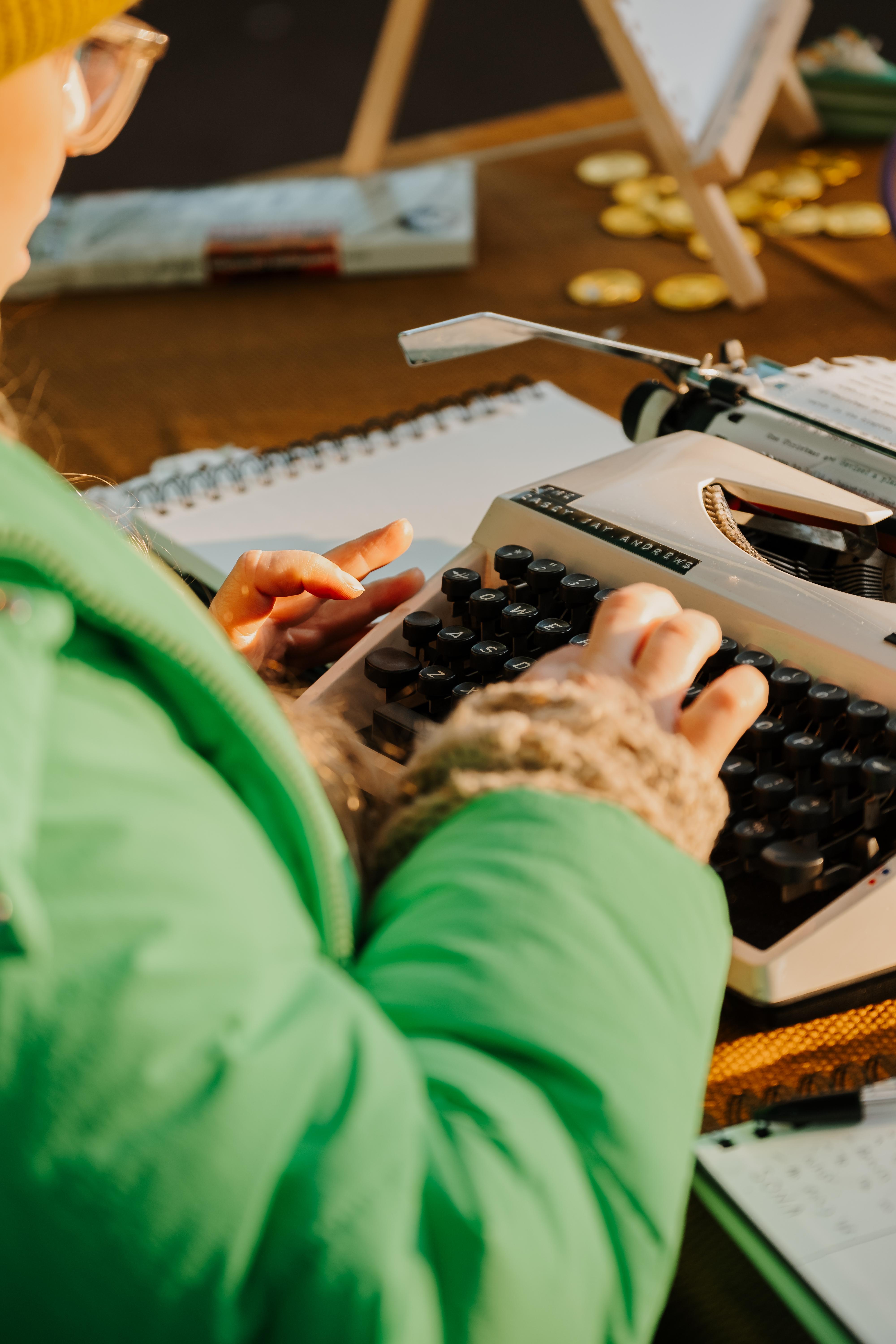 Image of a person writing a story on a typewriter.